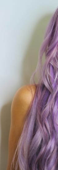 Portrait of a woman with long violet hair, representing Debonaire services